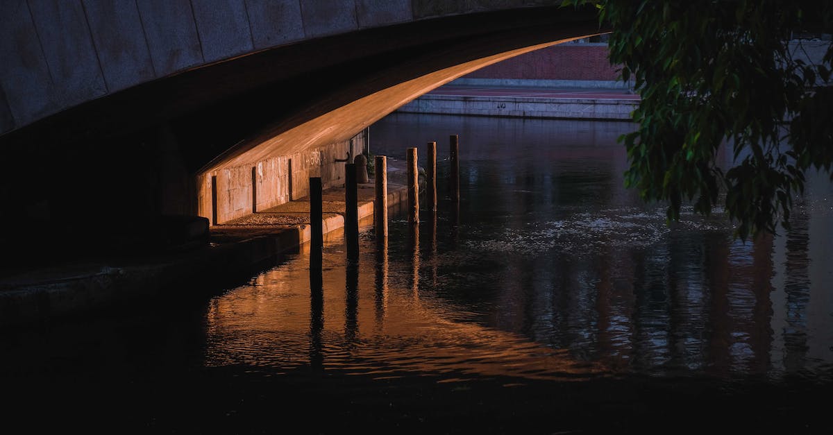 10 hour over night layover in Zurich - Narrow space and enclosure under concrete bridge over calm rippling river in dusk