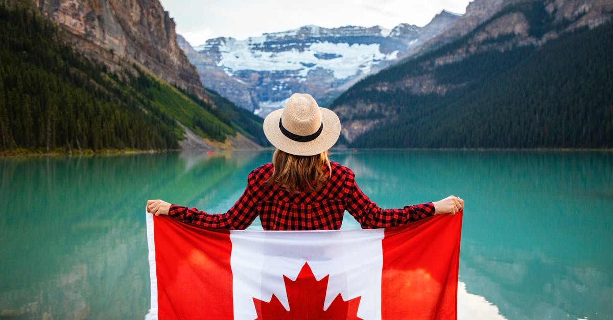 17 to canada and back [duplicate] - Woman Wearing Red and Black Checkered Dress Shirt and Beige Fedora Hat Holding Canada Flag Looking at Lake