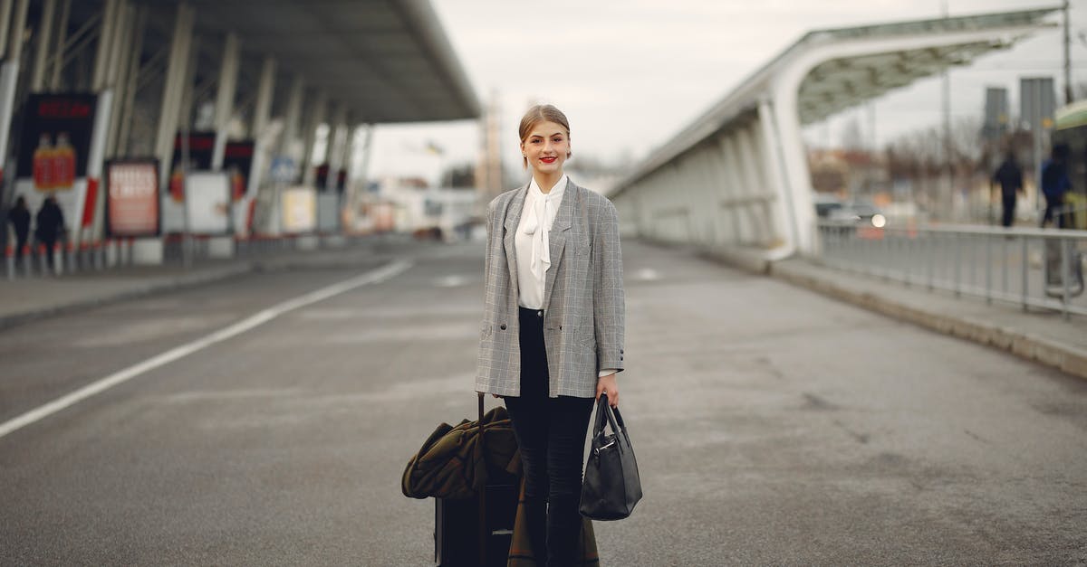 18h layover in Helsinki, can I leave the airport? - Happy female traveler walking on airport street with luggage