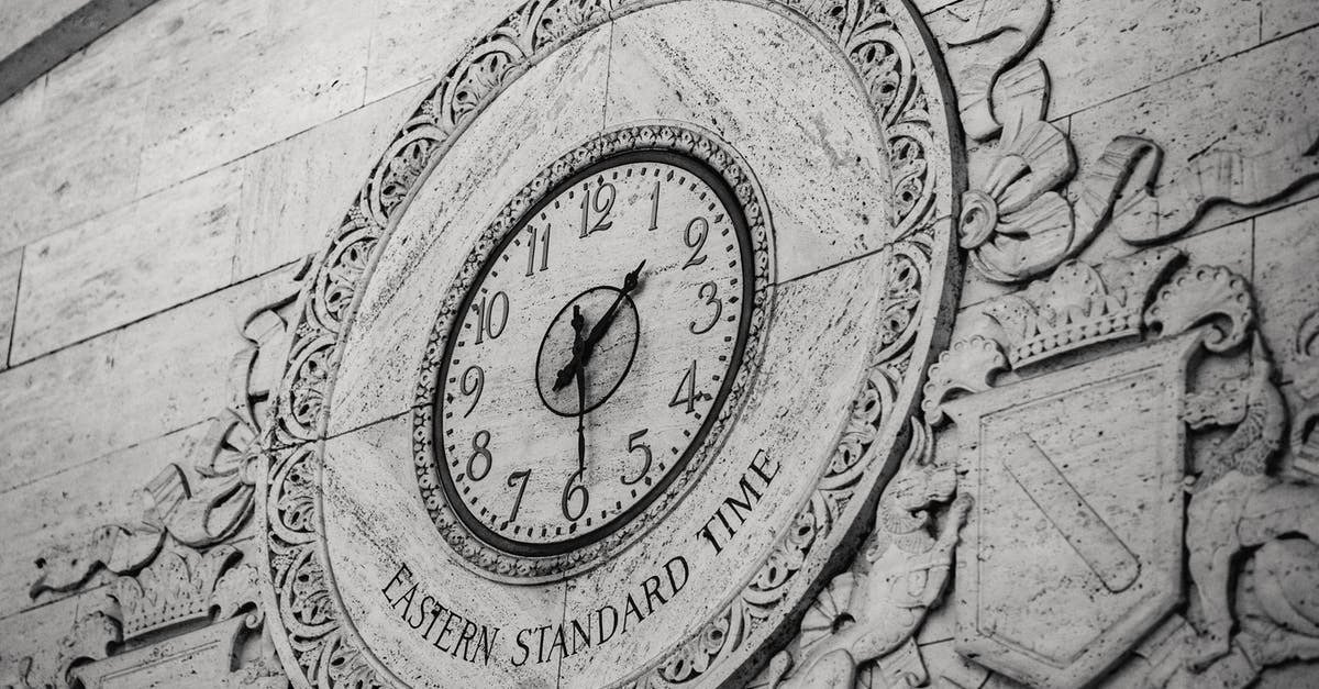 1 hour 10 minute layover in Addis Ababa? - From below black and white of stone wall with ornamental details around clock showing Eastern Standard Time