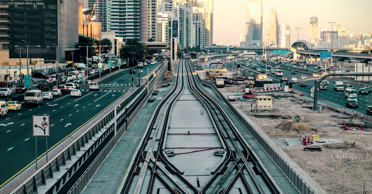 27 hours layover in Dubai and no valid visa - Tilt-shift Photography of Railway in Between of Roads at Day