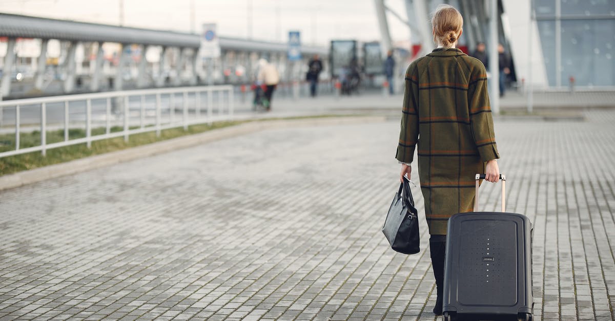 2 jetways for arrival of international flight at Newark? - Unrecognizable woman with suitcase walking near airport terminal