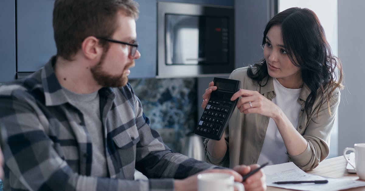 2 Months in Europe: Budget of $6000 - Man in Black and White Plaid Dress Shirt Holding Black Smartphone