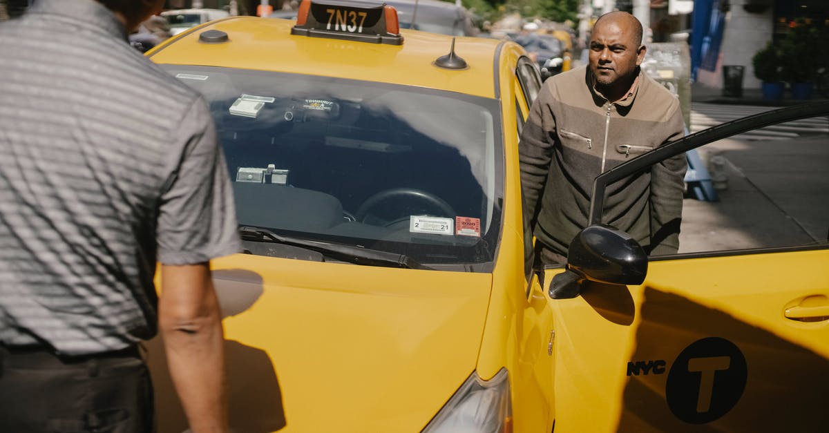 2-hour parking in the US - Serious ethnic cab driver having conversation with man in sunny day in New York