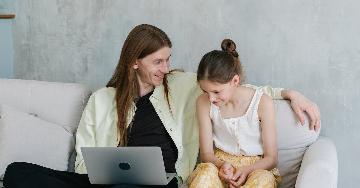 'One laptop per child'- like organisations? - Woman in White Tank Top Sitting on White Couch Using Macbook