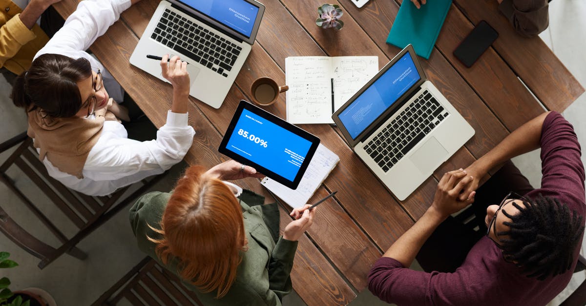 3 laptops and 2 tablets from Chicago to Chennai [duplicate] - Top View Photo of Group of People Using Macbook While Discussing