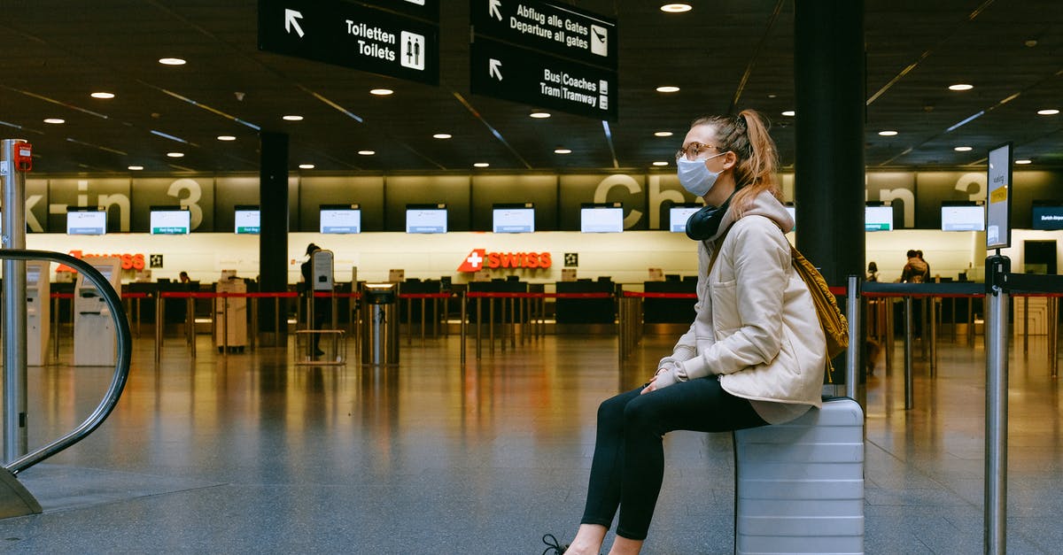 5-hour wait for a bus at Frankfurt airport - Woman Sitting on Luggage