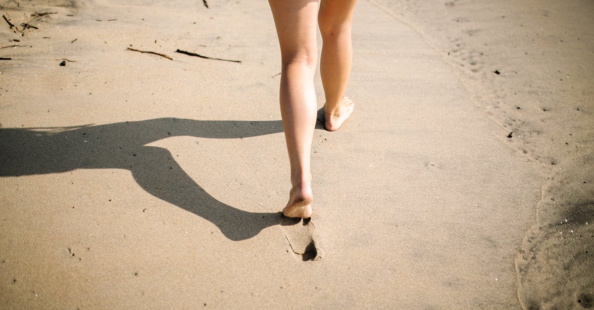 86 Day Internship in Germany - Woman in Blue Denim Shorts Walking on White Sand