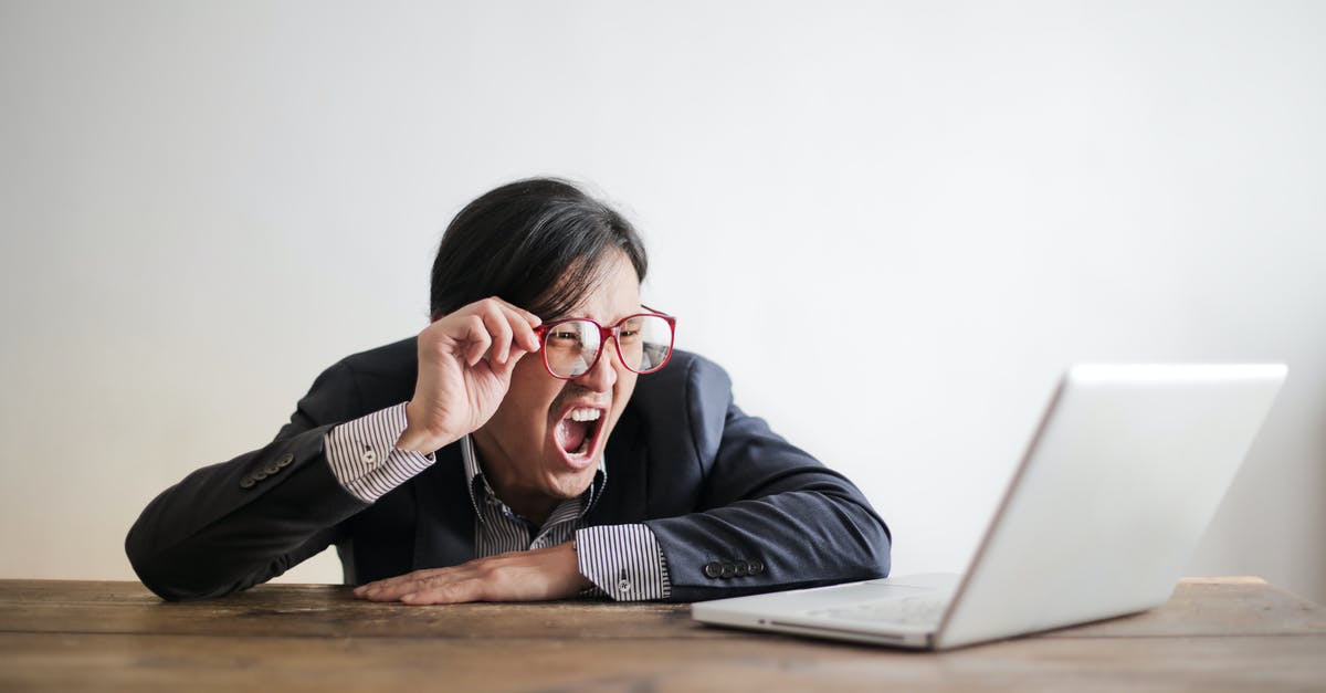 a mistake in my application [duplicate] - Modern Asian man in jacket and glasses looking at laptop and screaming with mouth wide opened on white background