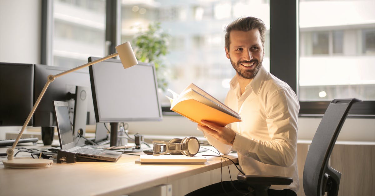 A normal desktop computer [closed] - Photo of Man Holding a Book