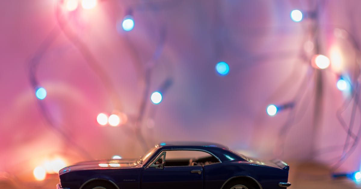 AAA benefits as member of a European automobile club? (IHG rates) - Selective Focus Photography of Classic Blue Coupe Die-cast Model in Front of String Lights on Table