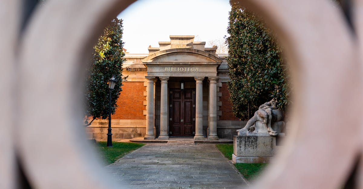 About entry in Europe [duplicate] - View through hole of gate on stone library with columns near sculpture in park