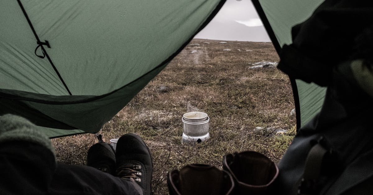 About staying in layover [duplicate] - A Person Wearing Black Shoes Staying Inside the Tent