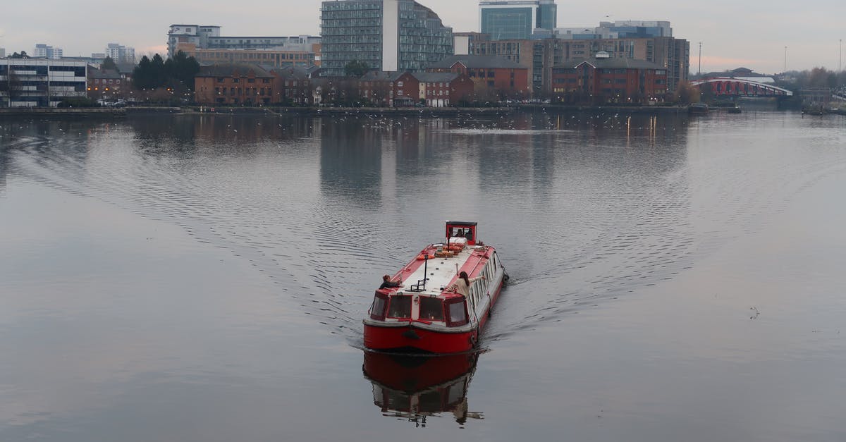 About to re-enter the UK - Red Boat on Body of Water Near City Buildings