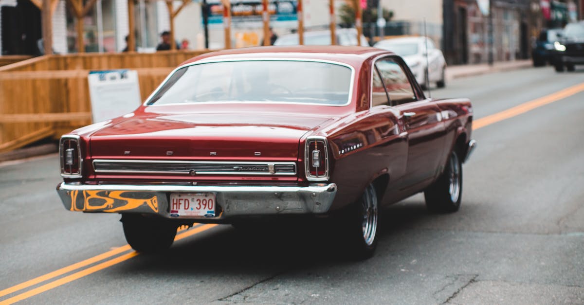 About UK driving license - Unrecognizable driver in retro car on road near urban buildings