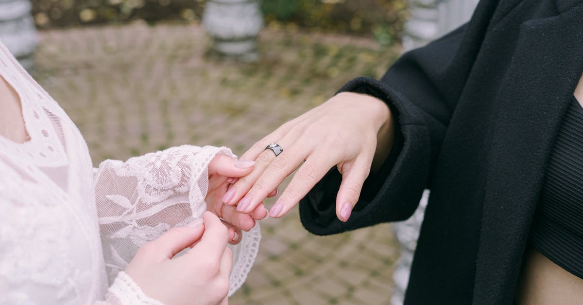 Acceptable terms for describing black people in California - Hand of Woman in White Lace Dress Holding Hand of Woman in Black Coat