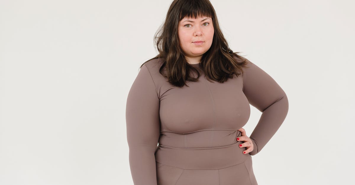 Acceptance of large bills in Denmark - Plus size female in activewear keeping hand on waist and looking at camera against white background