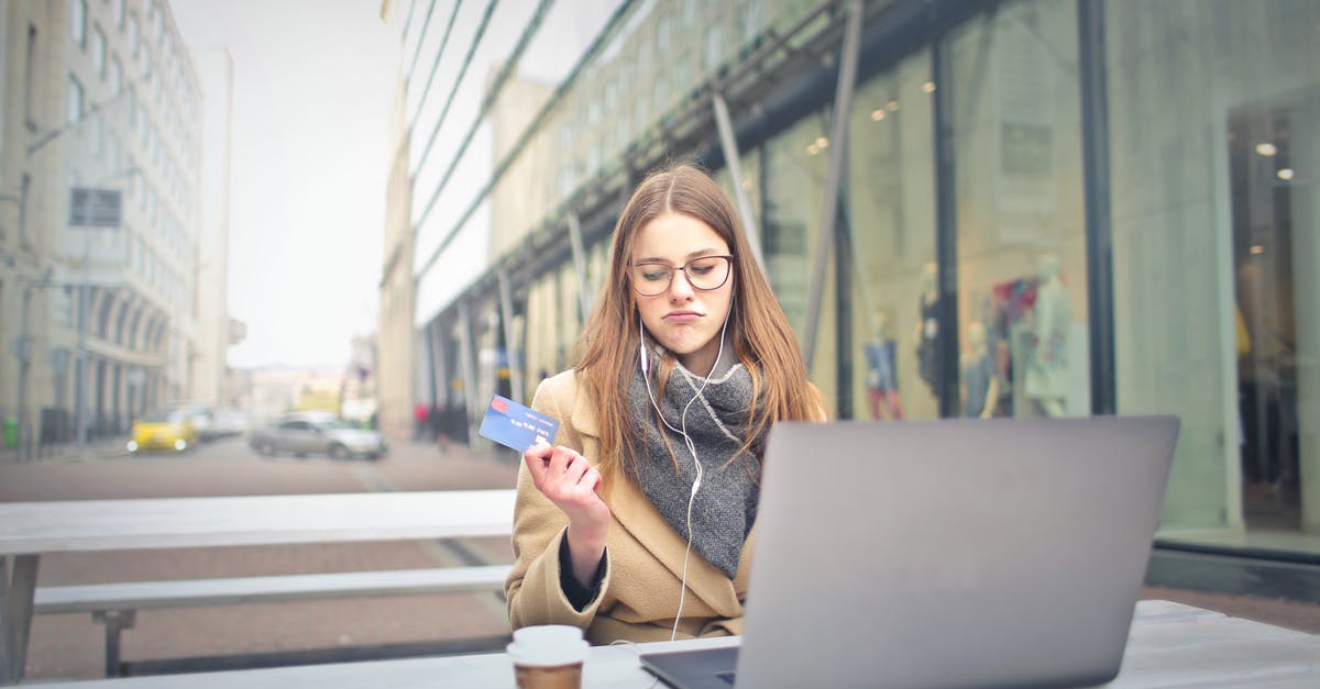 Access airport lounge with Gold/Premier credit card - Woman in Brown Coat Holding a Bank Card