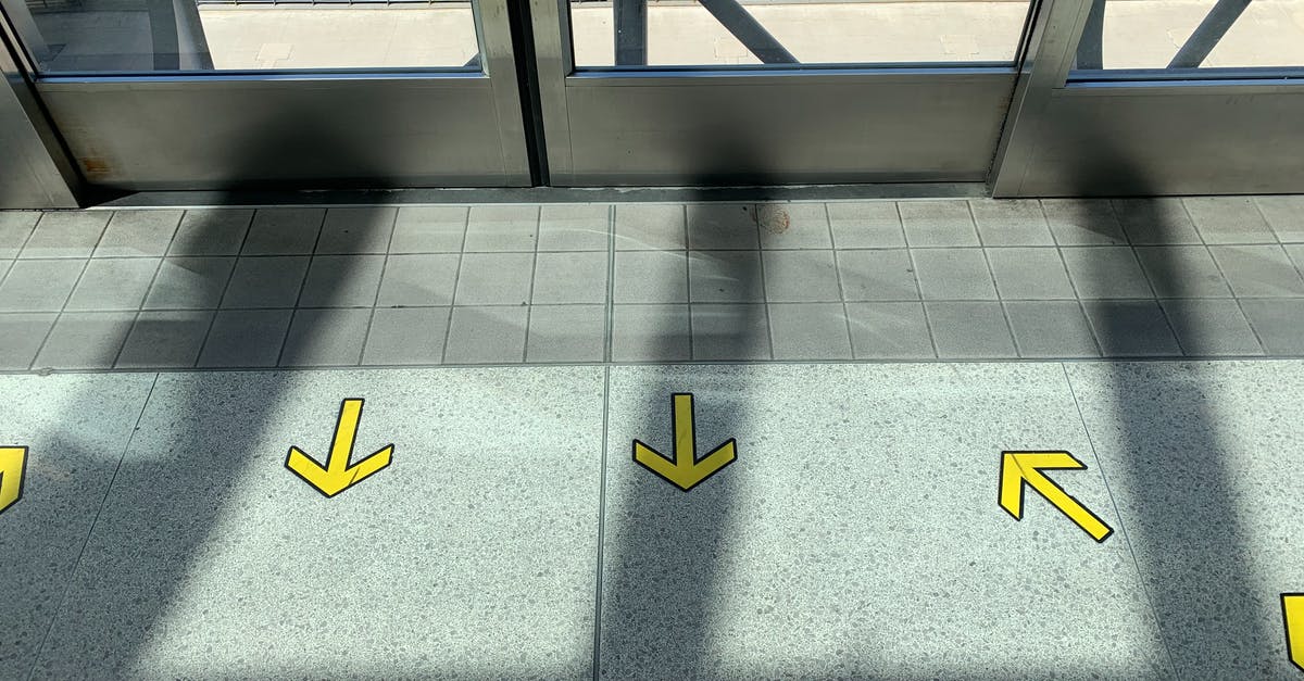 Accessing Karlsruhe from a major airport - Yellow arrows on tiled floor in building