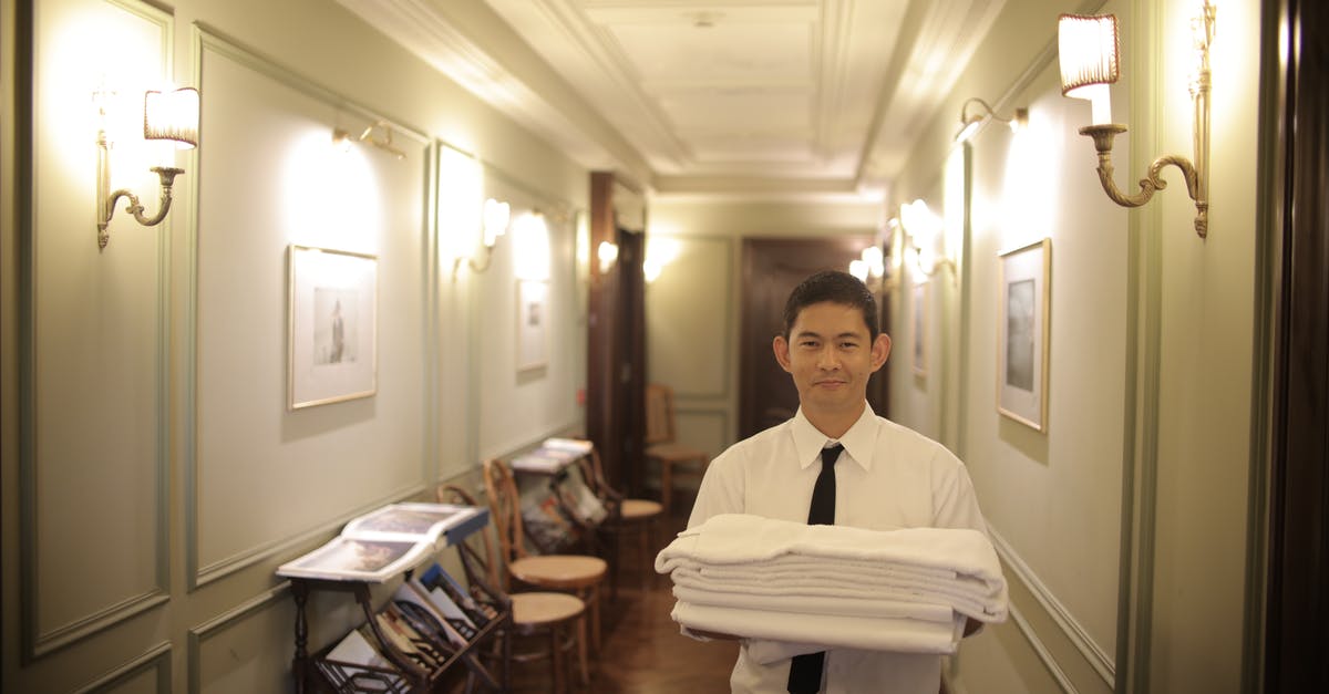 Accidentally booked hotel room twice - Man Holding White Linen Ad White Towel