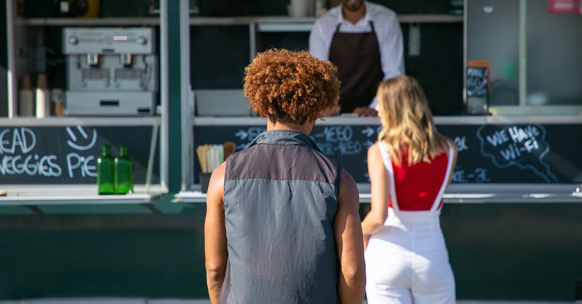 Accidentally left luggage abroad, and it's going to get shipped to me by a friend. Do I need to pay customs on getting my stuff back? - Back view of diverse clients standing near street food truck and choosing lunch