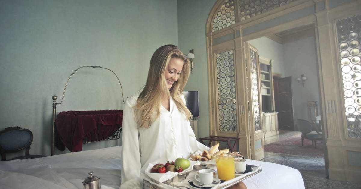 Accommodation, sights and food in Maui - Cheerful woman with breakfast on tray in hotel bedroom