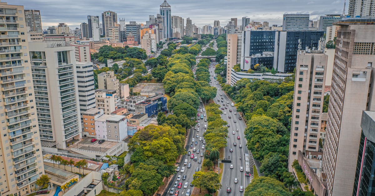 Accommodation while driving from Calais towards Paris - From above of asphalt roadway between contemporary high rise residential buildings and green trees in modern city under cloudy sky in daytime