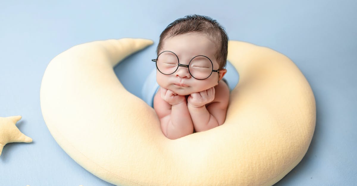 Adding a newborn child to US tourist visa (B1/B2) - Topless Boy Wearing Black Framed Eyeglasses Lying on Yellow Banana Bed