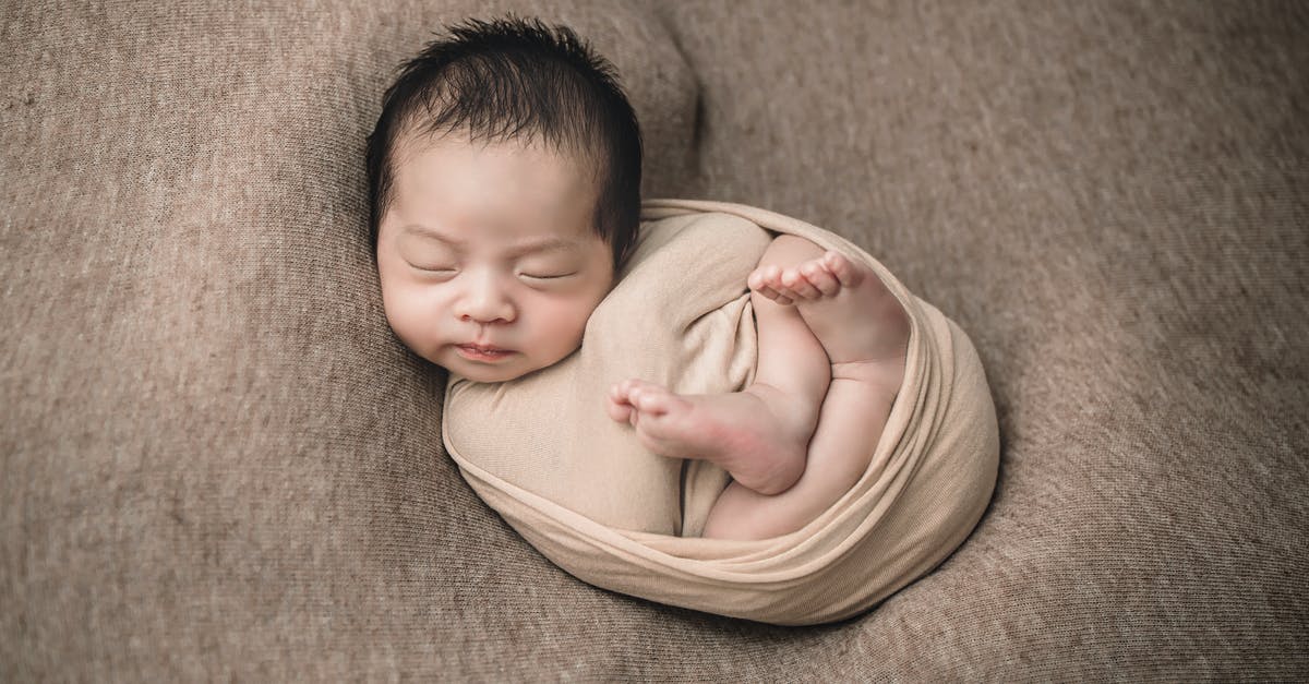 Adding a newborn child to US tourist visa (B1/B2) - Baby in Yellow Shirt Lying on Brown Textile