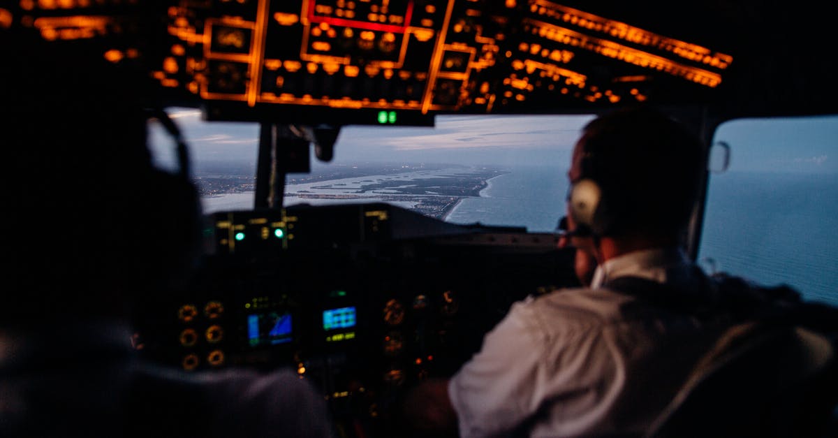 Additional cabin handbag on flights - Anonymous pilots in aircraft cockpit flying over sea