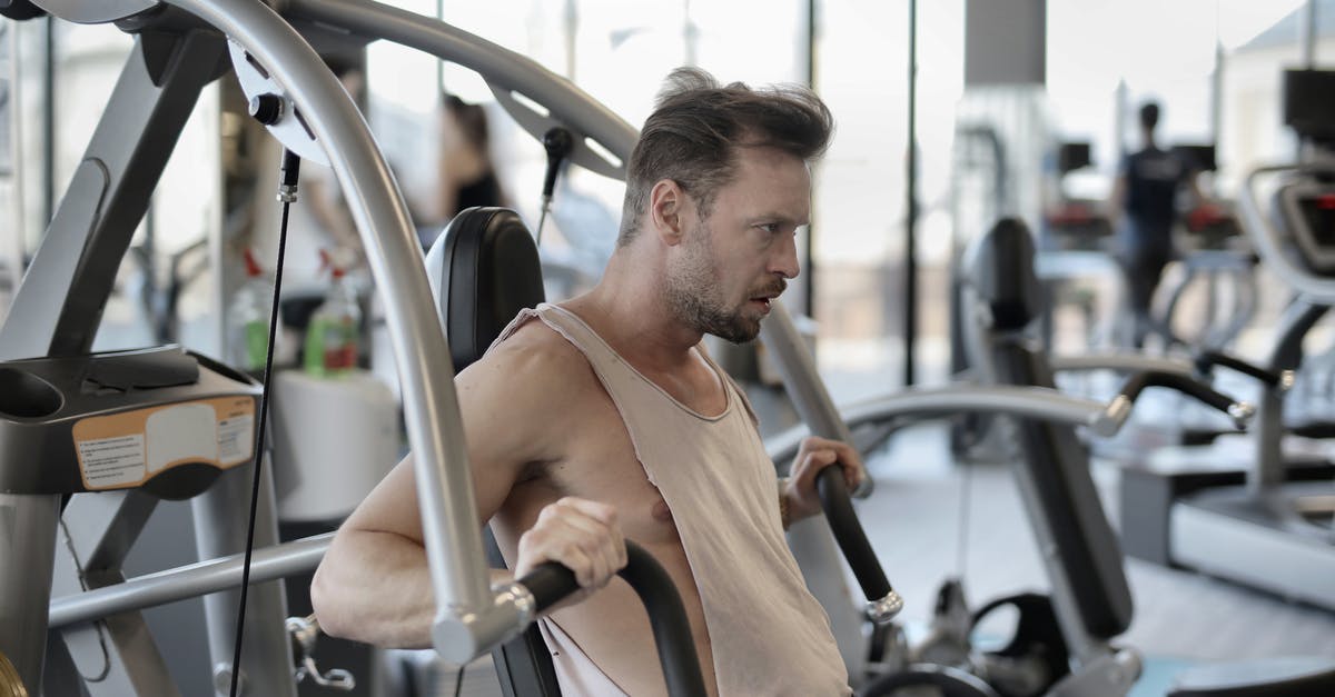 Additional weight when taking a bike with Air Brunei - Strong sportsman exercising with shoulder press machine in gym