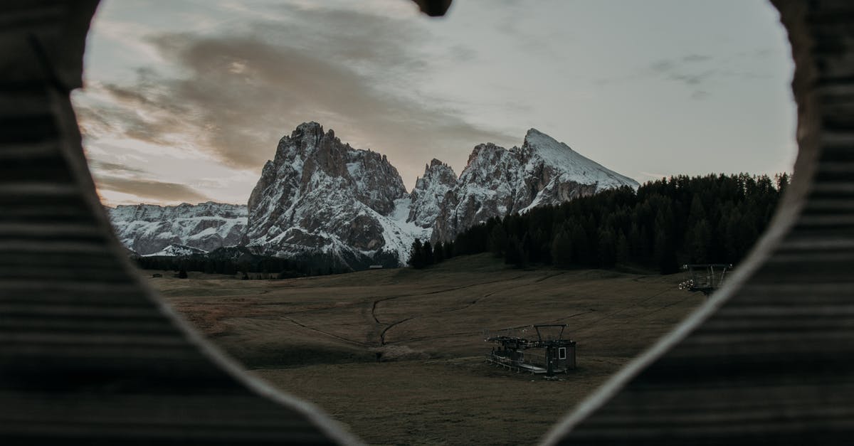 Address in Nepal field in visa application form - Through heart shaped hole of wooden fence on rocky cliffs covered with snow located on grassy field in rural area