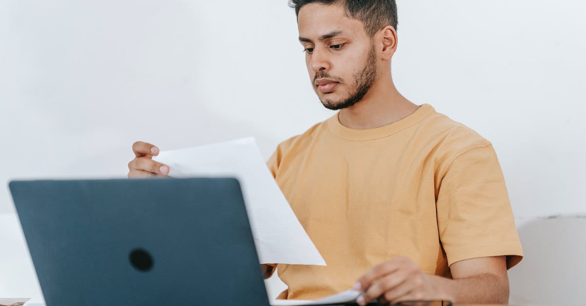 Administrative Review result mail - Visa Tier 4 Student [closed] - Young bearded Hispanic male university student reading information on paper while studying online via laptop