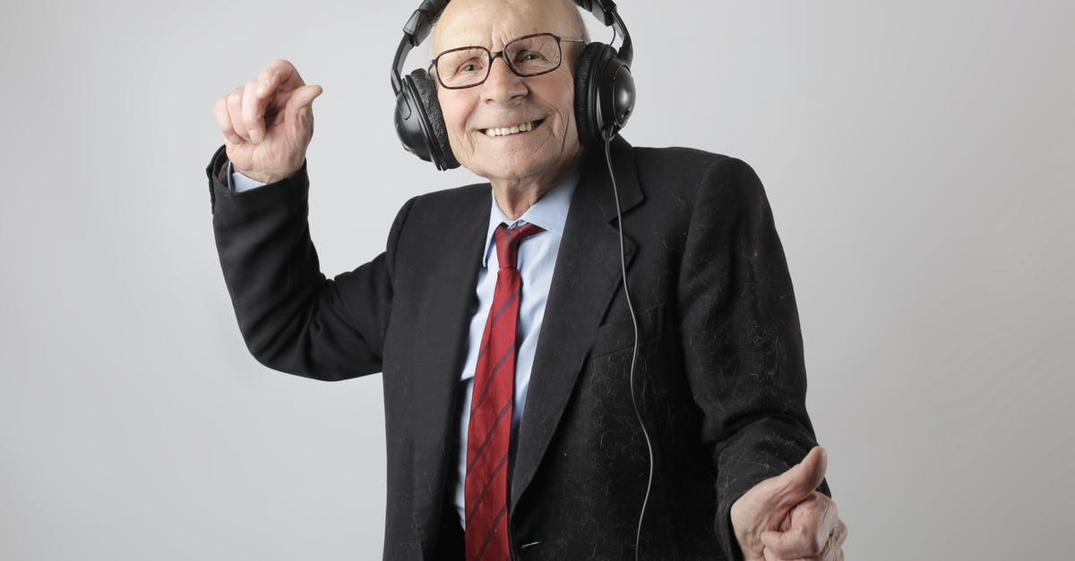 Adult entertainment, avoiding the awkwardness - Cheerful elderly man listening to music in headphones