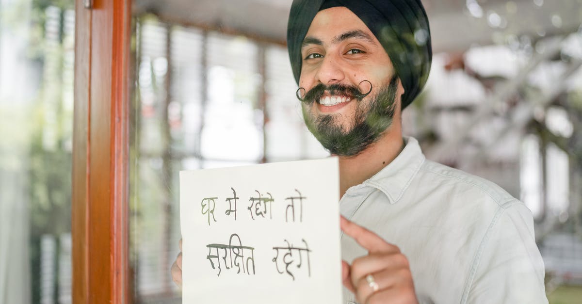 Advice on damaged Indian passport [duplicate] - Positive mature modern Sikh male in turban with curly mustache leaning against glass wall with sign in indian on paper sheet and looking at camera