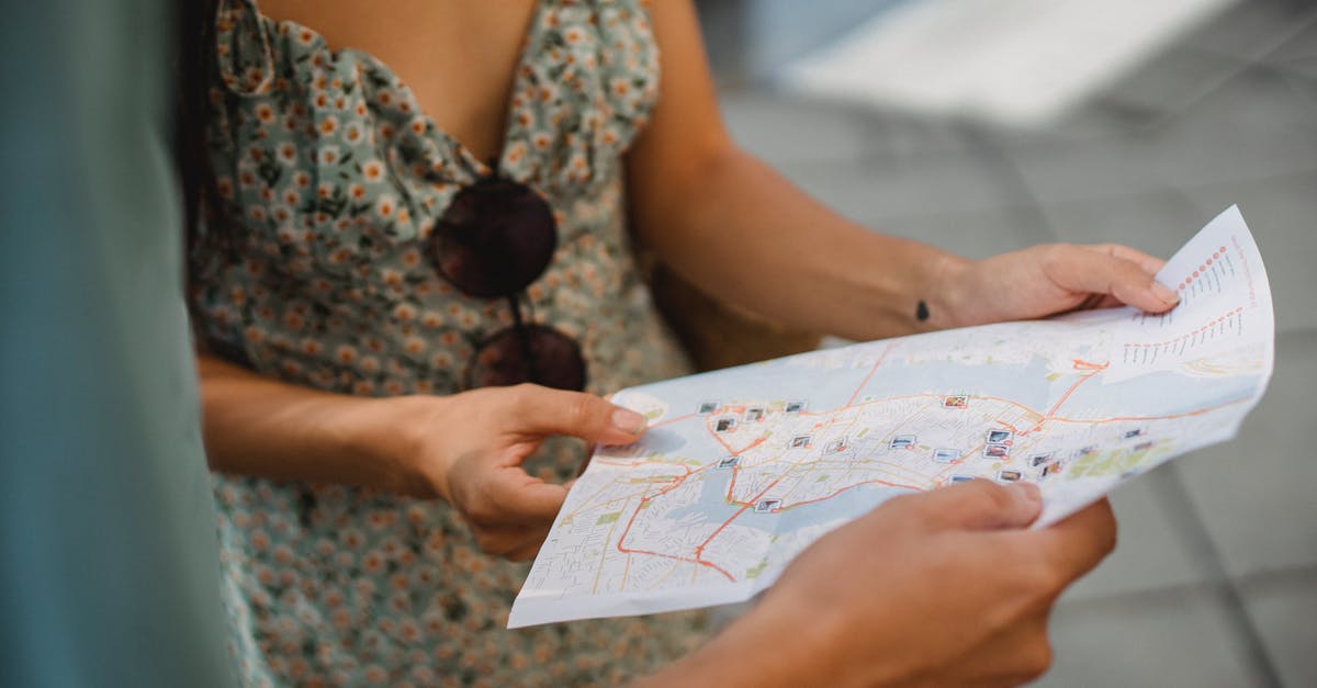 Advice on Hotel - Travelling to visit my girlfriend in Russia - Crop anonymous couple travelers in summer clothes checking location in paper map while walking in unknown city