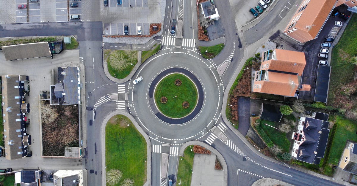 Affordable and accessible accommodation options with car parking near Paris? - Drone top view over modern roundabout road located amidst suburban houses and big parking area