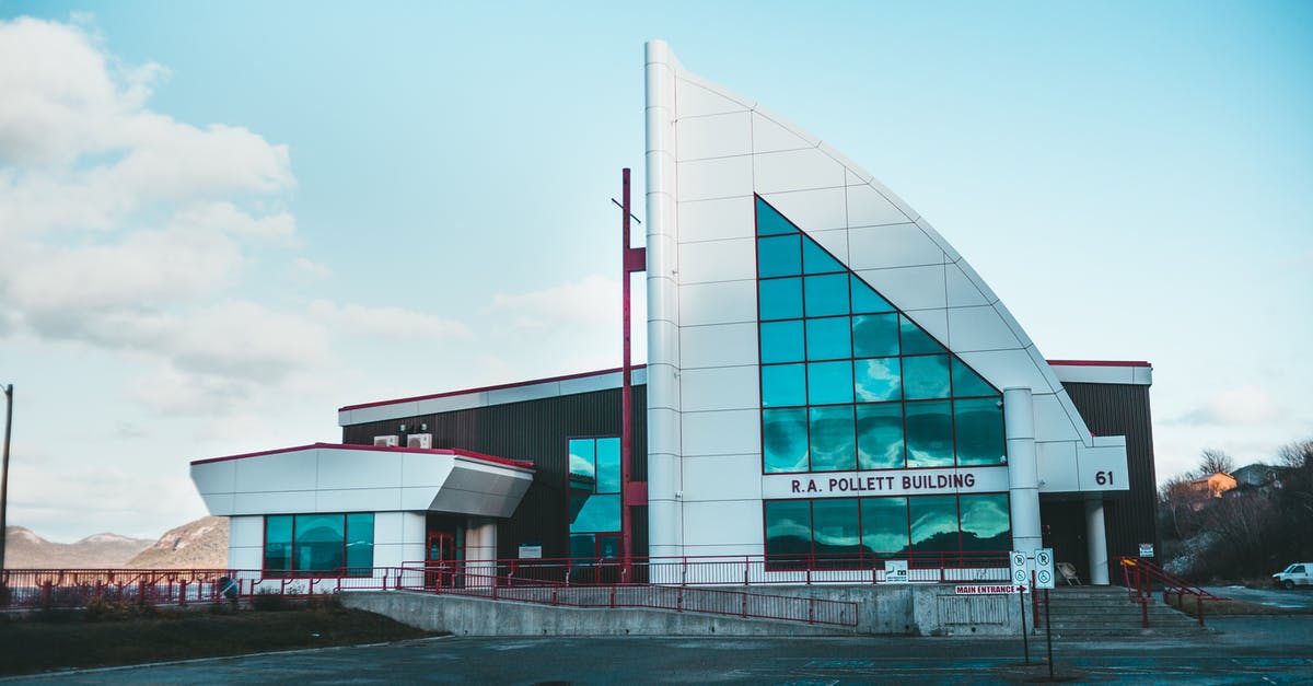 Air Canada - Unintentional "Hidden City Ticketing" - Pavement against modern real estate corporation facade reflecting mount and cloudy sky in Corner Brook Canada