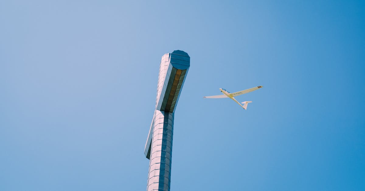 Air Canada luggage allowance when flying from Europe to USA - From below of high metal Nivolet Cross with plane flying over cloudless blue sky in France