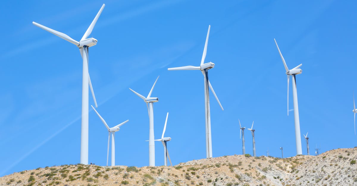 Air NZ Status Tier renewal (downgrade from Gold to Silver) - From below of tall wind energy converters with long thick steel towers and rotor blades under blue sky in sunlight