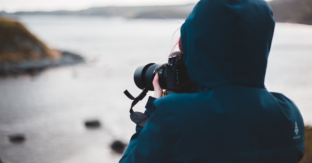 Air travel using foreign passport with maiden name [duplicate] - Unrecognizable female photographer with photo camera near ocean