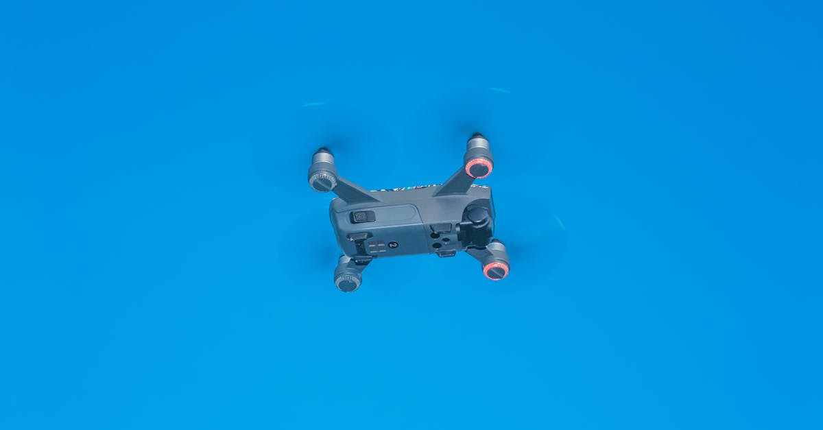 Air Travel with an Electric Arc Lighter - From below of side part of remote control drone with quickly spinning propellers and small cameras for taking photos and videos