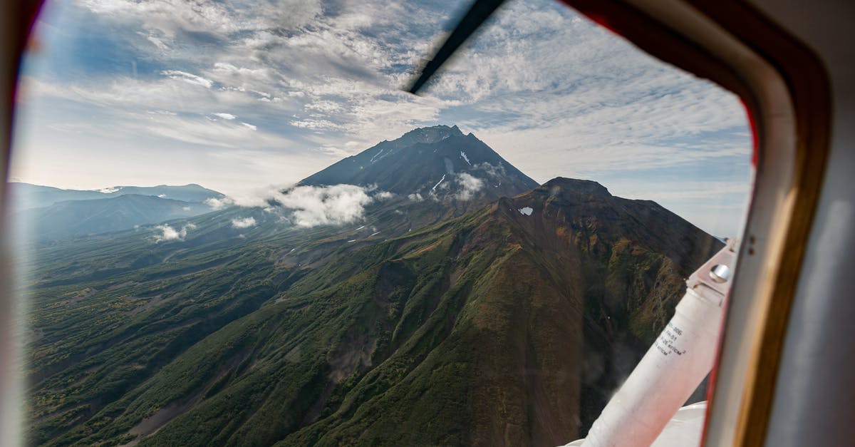 Air Travel with pet Budgie - Green and Brown Mountains Under White Clouds