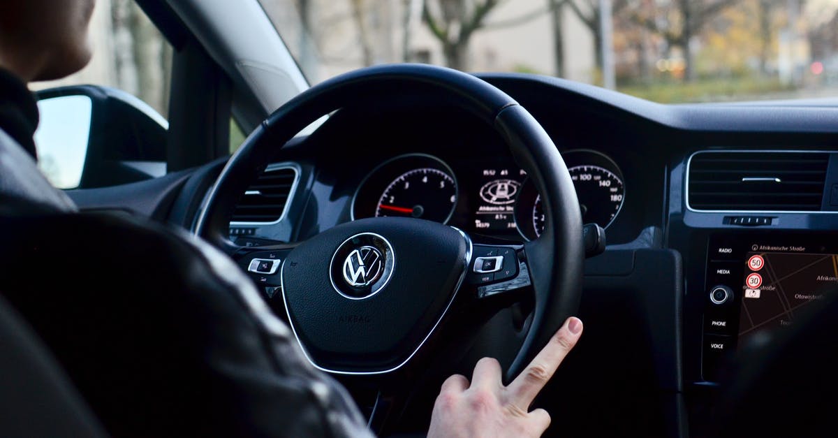 AirBNB for Ukrainian eVisa or Passport Control - Back view of crop anonymous male driving contemporary transport while turning steering wheel in daylight