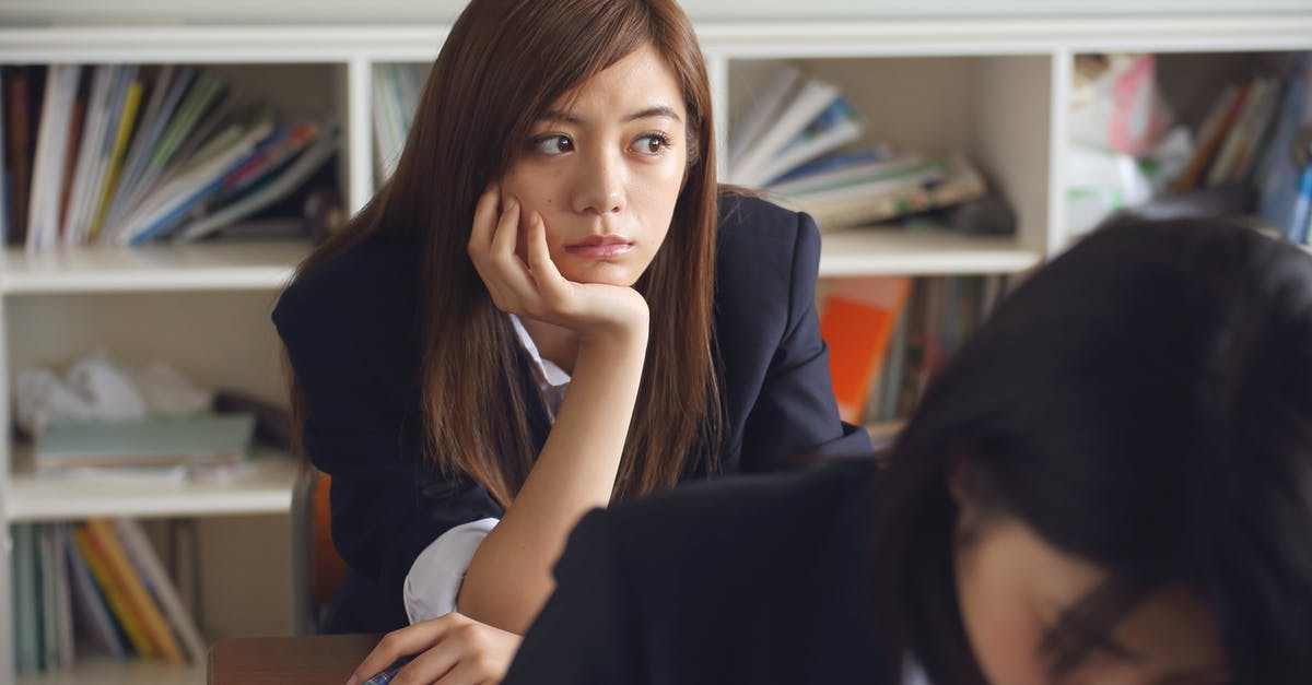 Airfare booking class, sub-class and perks - Woman Holding Chin Sitting Beside Table in Room