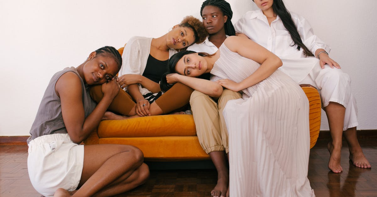 Airlines and different passports - Photo of Women Sitting on Orange Sofa