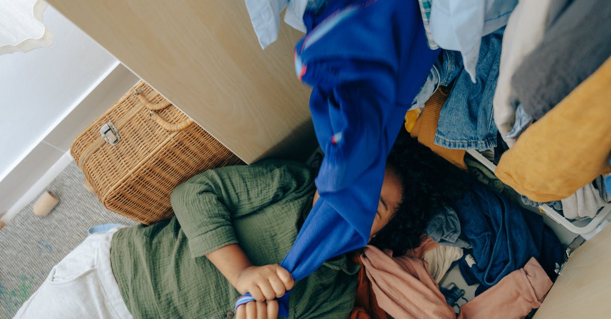 Airplane Seats and overhead storage - Anonymous black girl lying on stack of clothes in bedroom