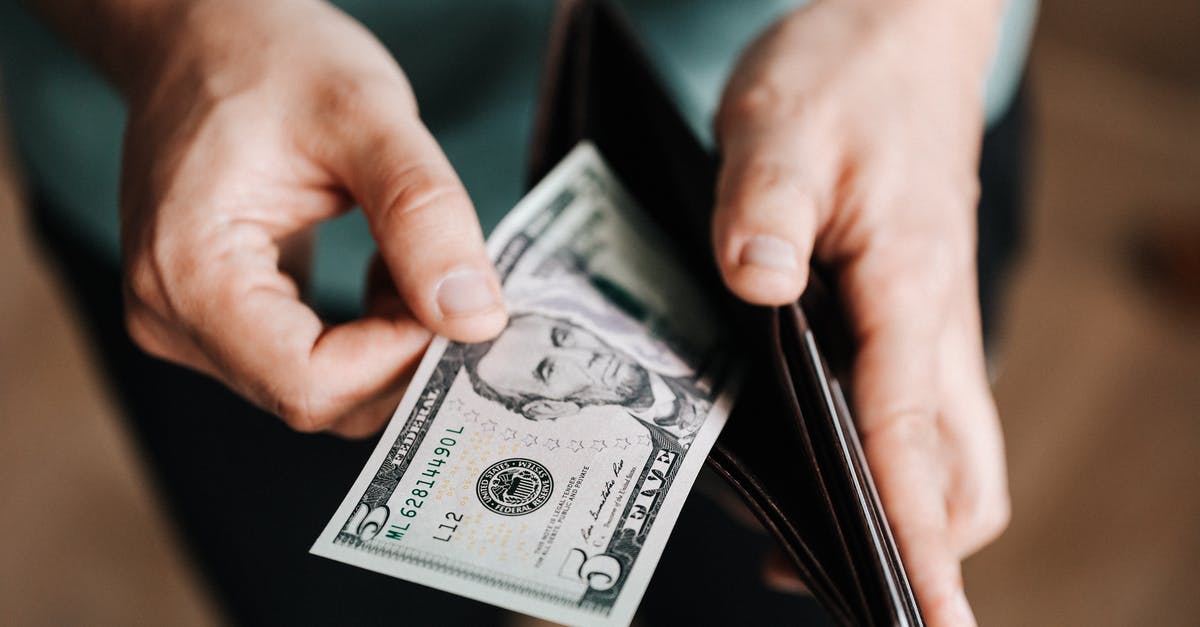 Airport Change from La Guardia TO JFK [duplicate] - Unrecognizable man holding wallet with money