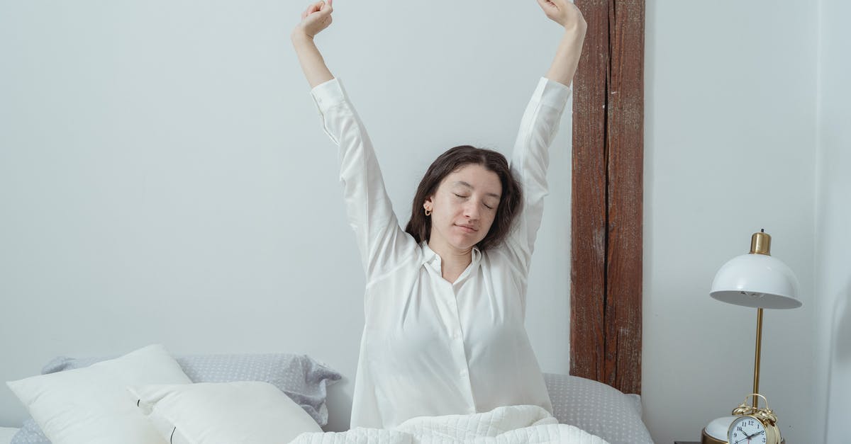 Alarm Clock without Noise? To wake up in common sleeping rooms and airports without noise? - Sleepy woman waking up on bed in morning