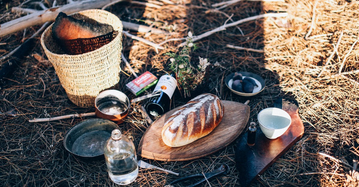 Alcohol as necessary medicine when visiting dry countries? - Bread and utensil near bottles and basket on grass